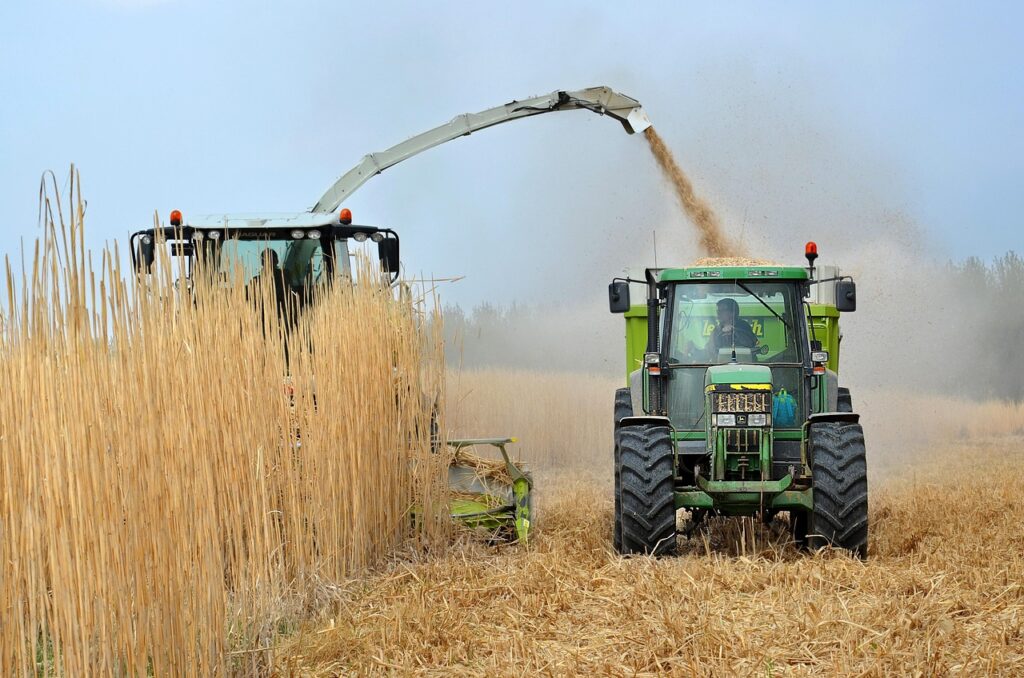 A modern tractor harvesting crops after they have been treated with chemical solutions.